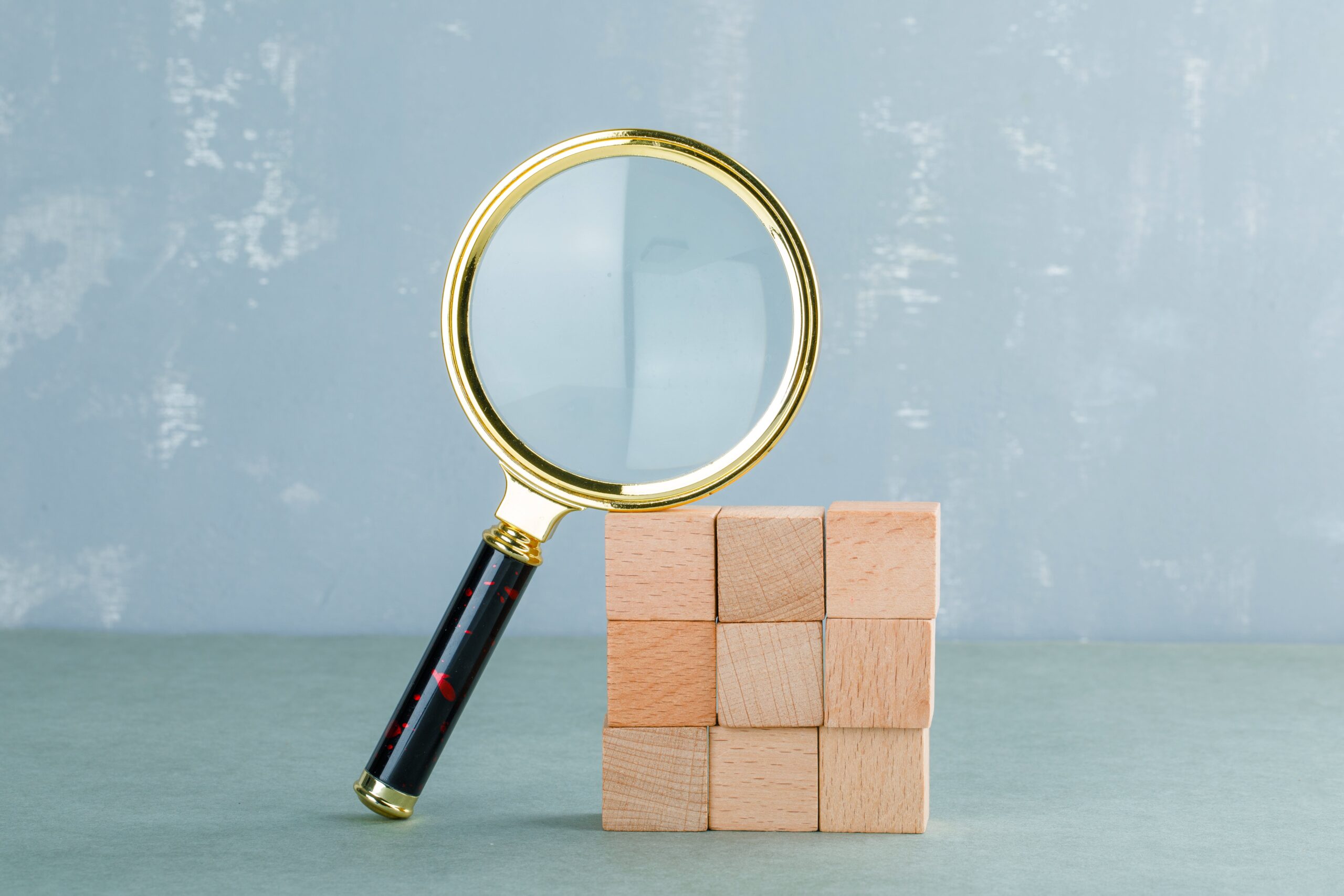 conceptual-search-with-wooden-blocks-magnifying-glass-side-view-min